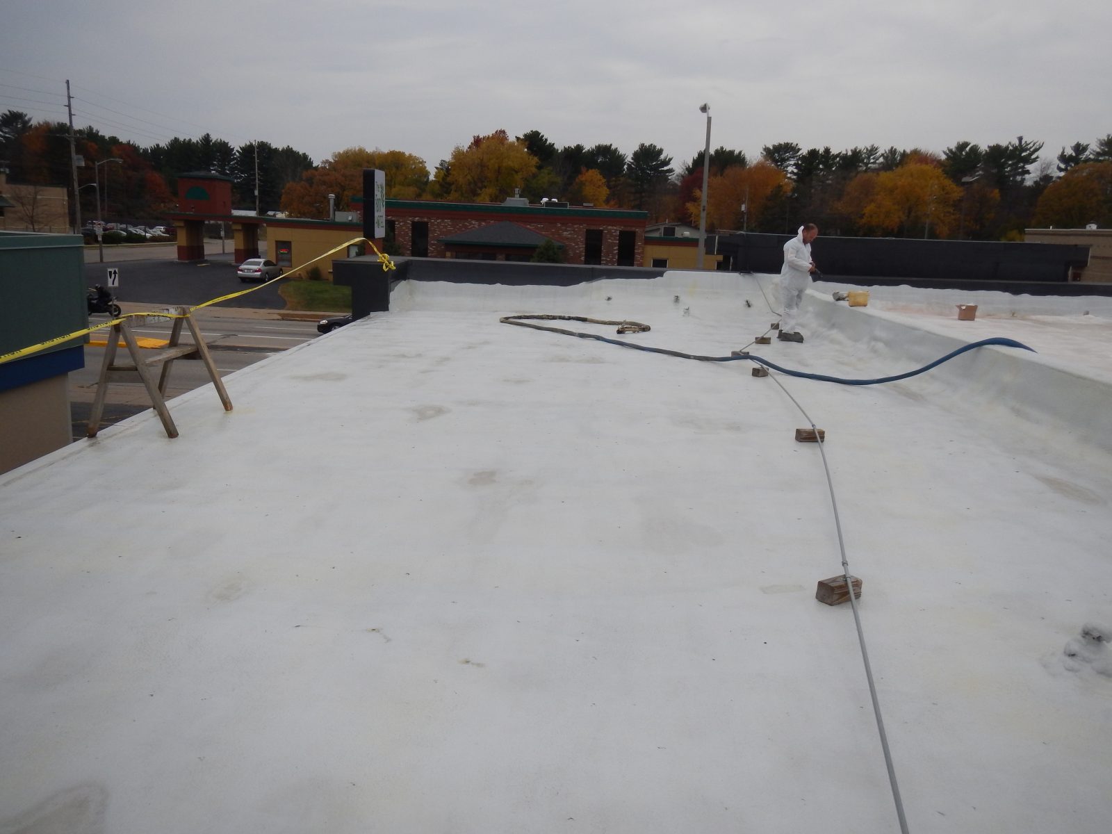 Standing seam metal roof being coated with polyurea membrane