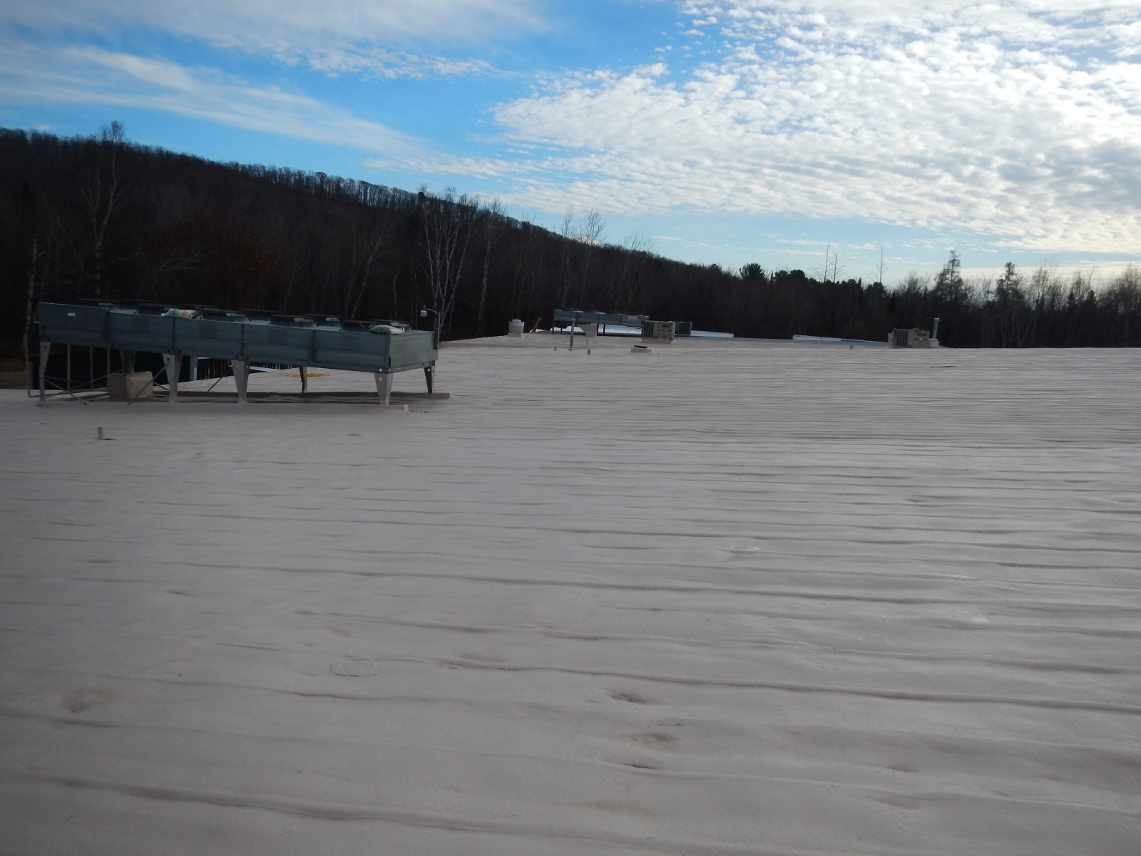 High-build polyurea coating on an impact-exposed metal roof
